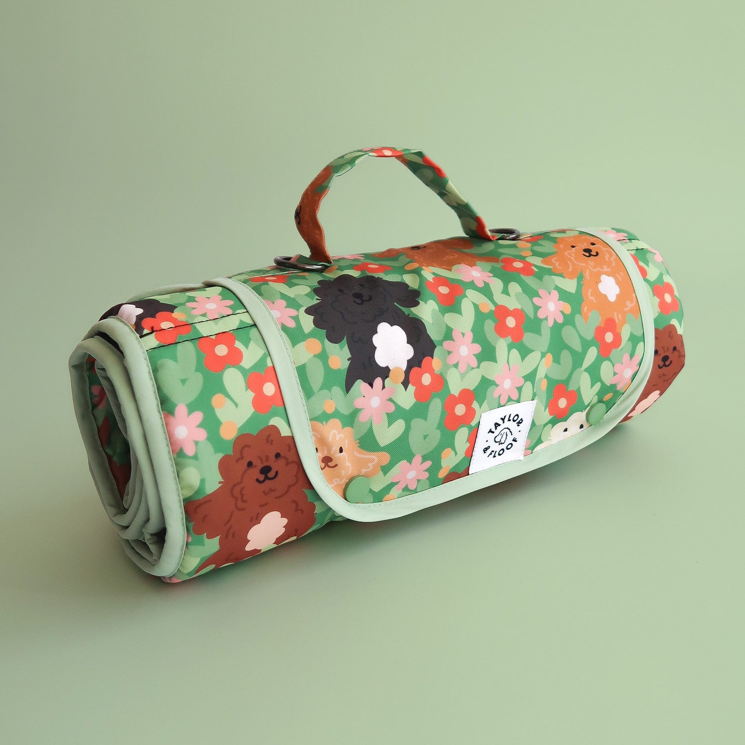 Rolled up settle mat with cockapoo and doodle dog illustrations with flowers on a light green background. Portable dog mat for training, travel, and creating calm spaces for dogs anywhere.