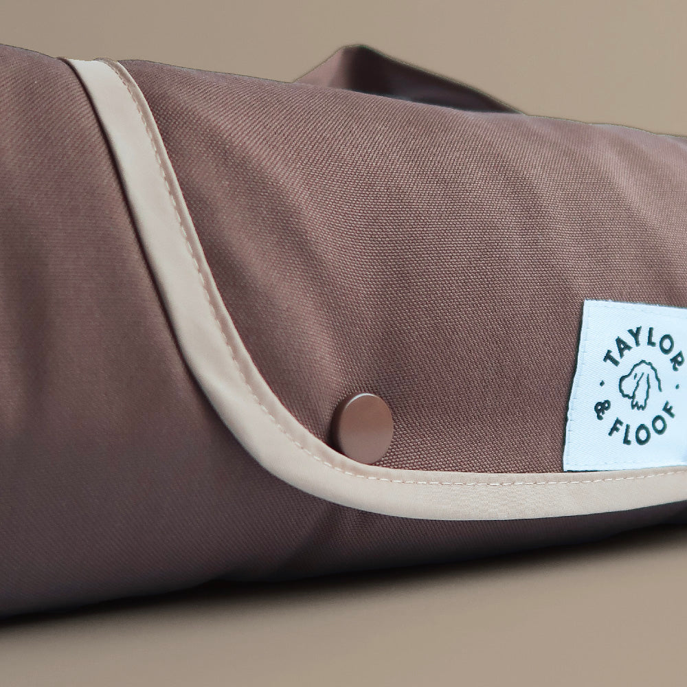 Close-up of mocha brown dog settle mat showing durable fabric and soft cream trim.
