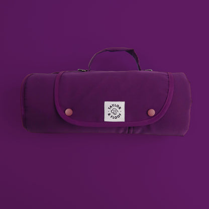 Purple settle mat rolled with a logo on a matching purple background