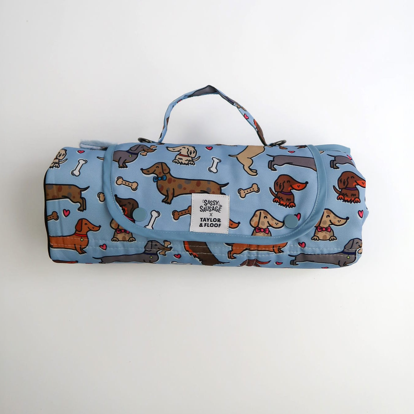 Foldable dog mat with dachshund pattern on a blue background. Sassy Sausage and Taylor and Floof collaboration 