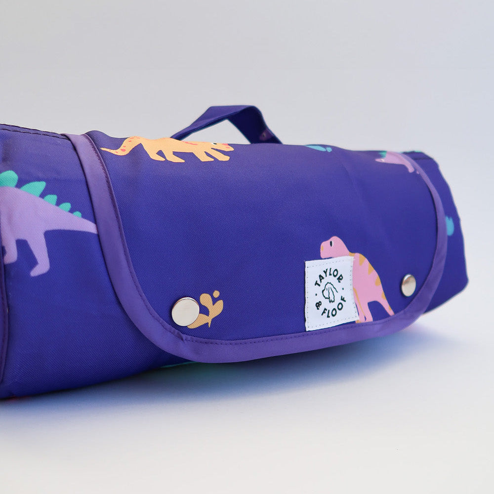 Purple Dinosaur Travel Mat for Dogs – Bright and playful dino-printed dog mat with a purple background, designed for crate use, puppy training, and cozy settling at home or on the go.