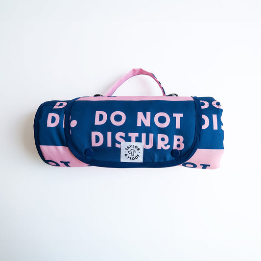 Rolled up Do Not Disturb 2.0 dog settle mat in pink and blue by Taylor and Floof, waterproof and non-slip design for settle training.