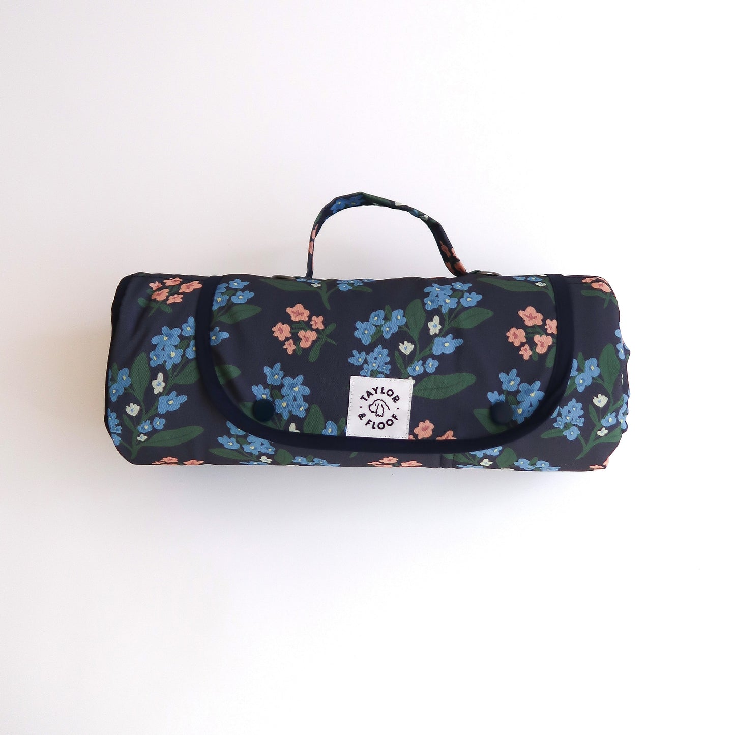 Dark blue settle mat for dogs with pink and blue florals on. On a white background with a taylor and floof logo