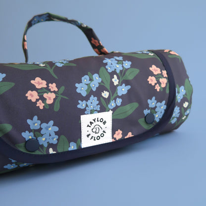 Portable dog mat in dark blue with pink and blue florals. 