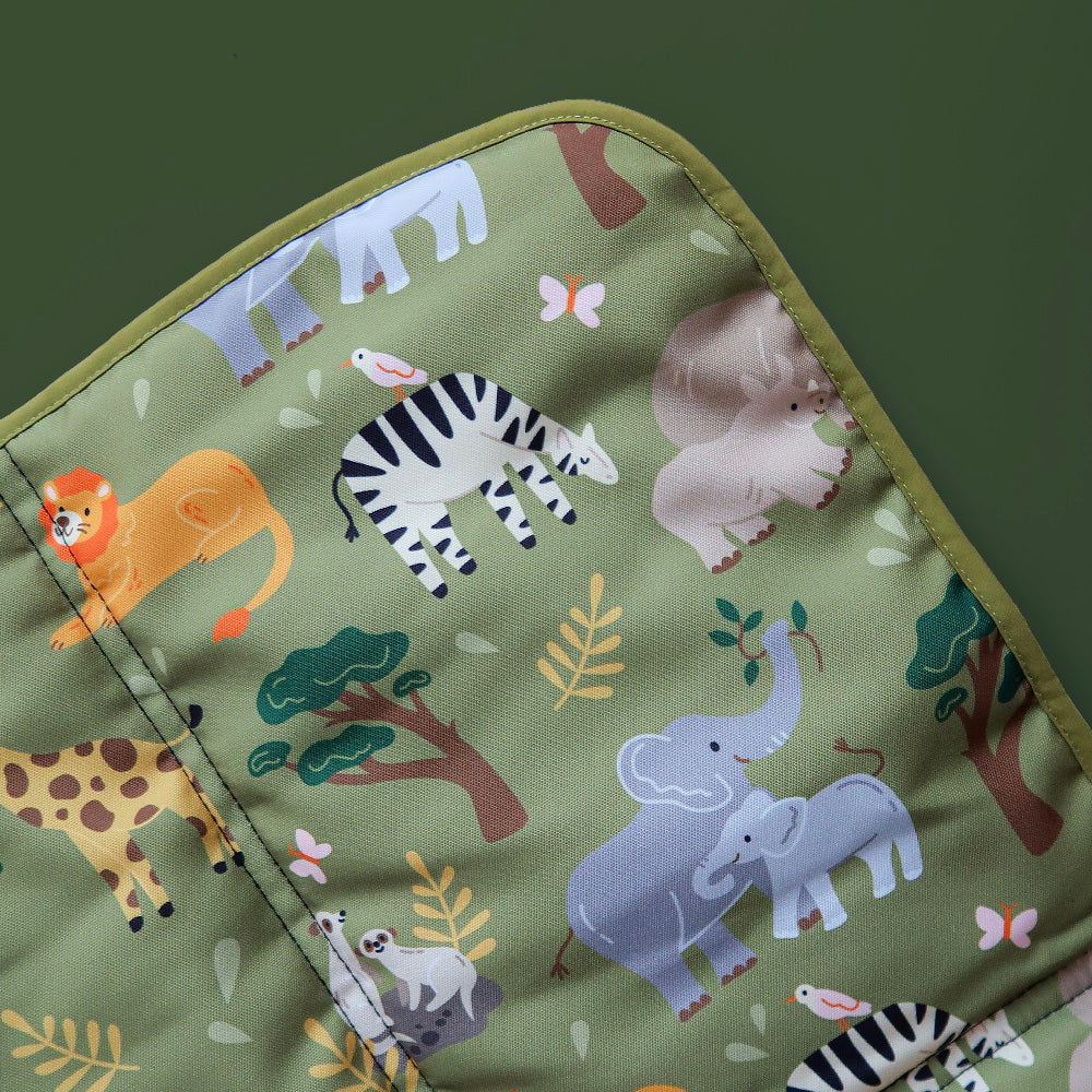 Close-up of safari animal dog mat featuring elephants, rhinos, giraffes, lions, and meerkats on soft, wipeable fabric.